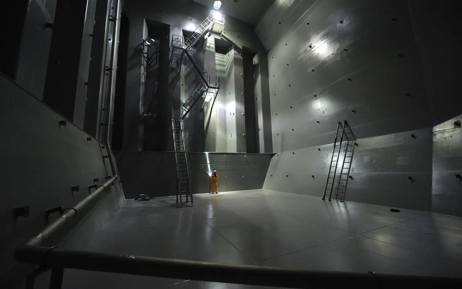 Inside of a coated industrial tank with worker for scale